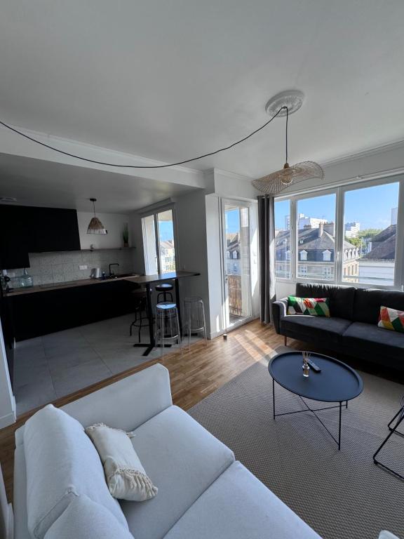 un salon avec un canapé blanc et une table dans l'établissement Charmant appartement t3 avec balcon, centre-ville, à Lorient
