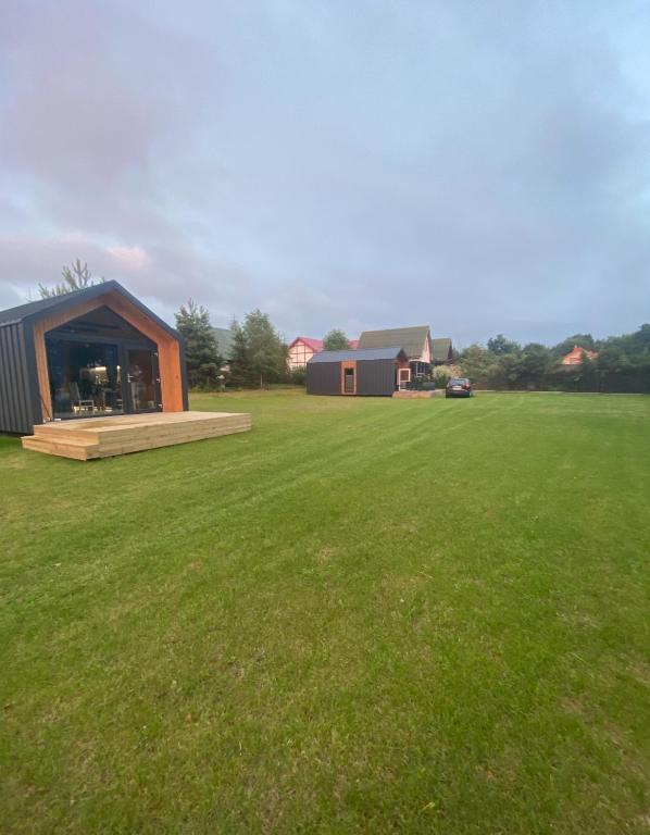a large grassy field with a building in the background at Domek Lubkowo Holliday in Lubkowo