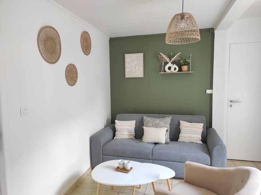 un salon avec un canapé bleu et une table dans l'établissement 4- Le Sauvage - Sarlat - Centre Ville, à Sarlat-la-Canéda