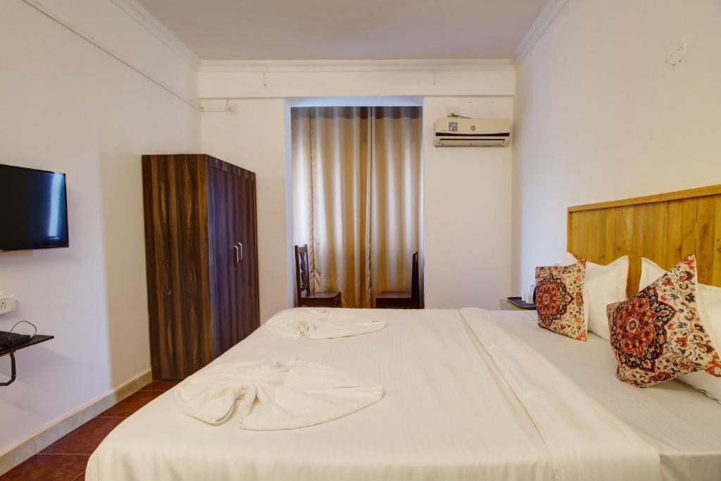 Postel nebo postele na pokoji v ubytování Hotel pleasure inn near turtle beach morjim Manage by ld group of hospitality
