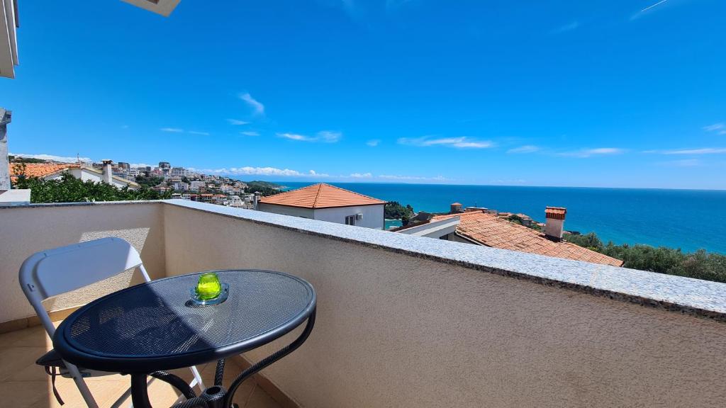 a table on a balcony with a view of the ocean at Apartments Mare in Ulcinj