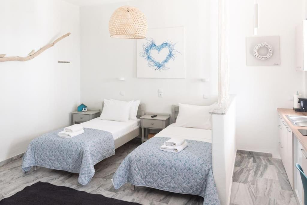 a white room with two beds and a table at Swell S9 new studio in Naousa in Naousa
