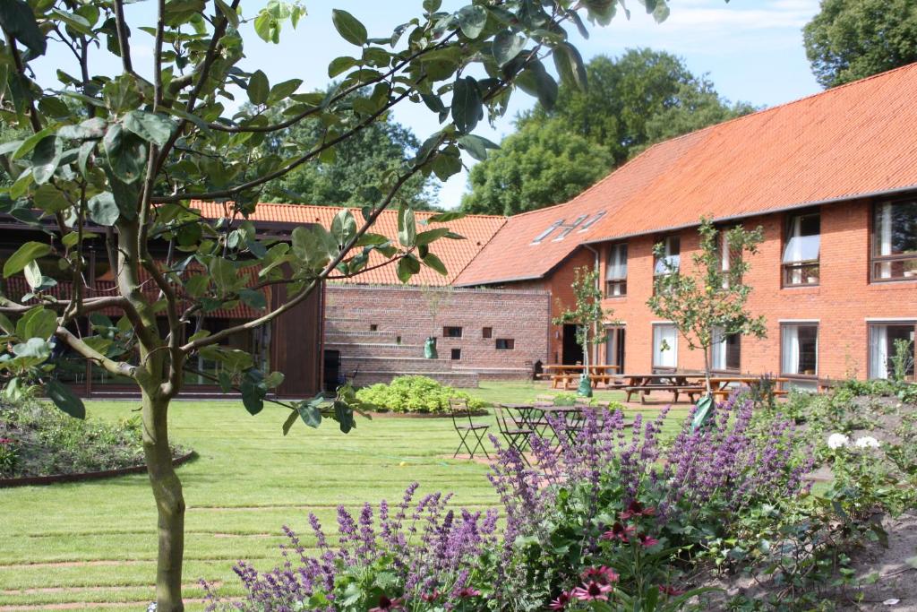 a garden in front of a building with purple flowers at Løgumkloster Refugium in Løgumkloster