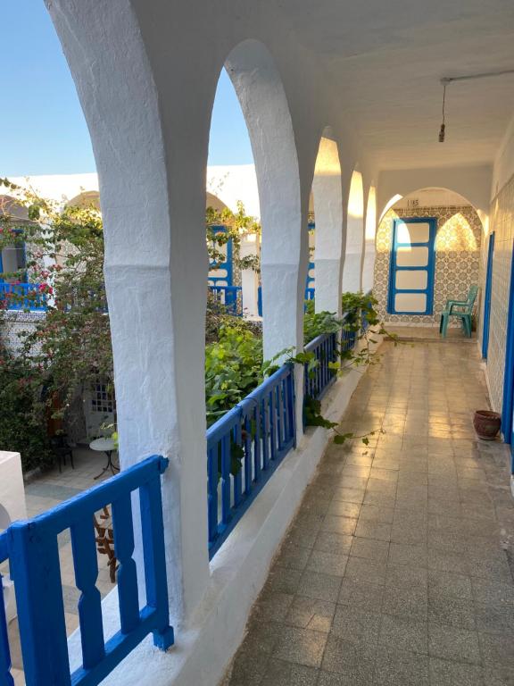 a hallway of a building with a blue fence at Hôtel Sindbad in Houmt Souk
