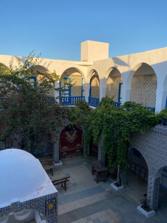 a courtyard of a building with a fireplace and benches at Hôtel Sindbad in Houmt Souk