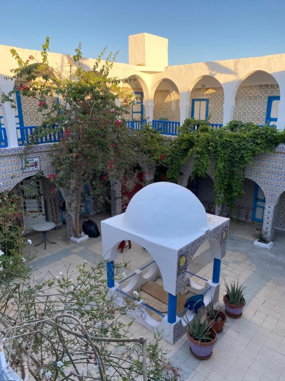 a white table in front of a building with plants at Hôtel Sindbad in Houmt Souk
