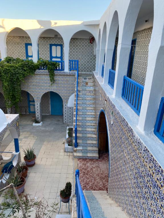a courtyard of a house with blue and white walls at Hôtel Sindbad in Houmt Souk