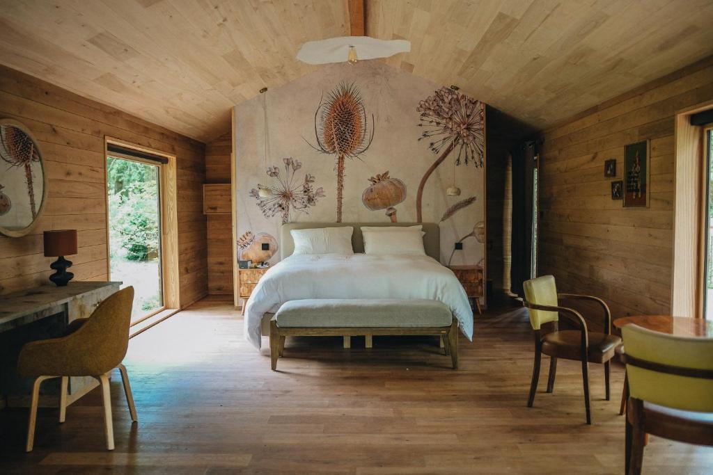 ein Schlafzimmer mit einem Bett und einem Tisch und Stühlen in der Unterkunft BANDIAT Le Domaine in Fargeas