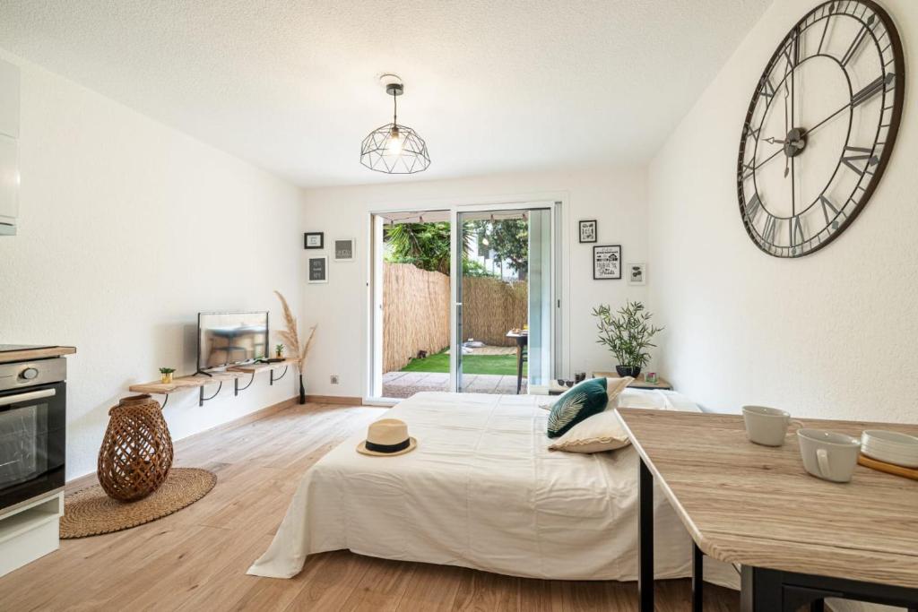une chambre avec un lit et une horloge au mur dans l'établissement Relax Garden, Swimming pool in French Riviera, à Cagnes-sur-Mer