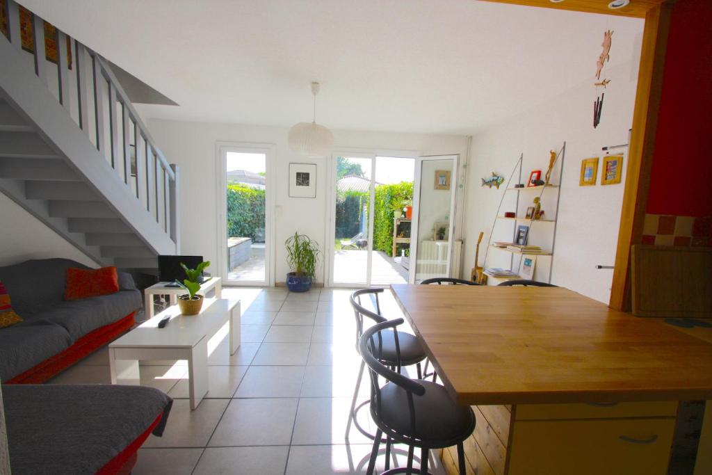 un soggiorno con un tavolo e un divano di Maison 2 chambres avec jardin et piscine a La Teste-de-Buch