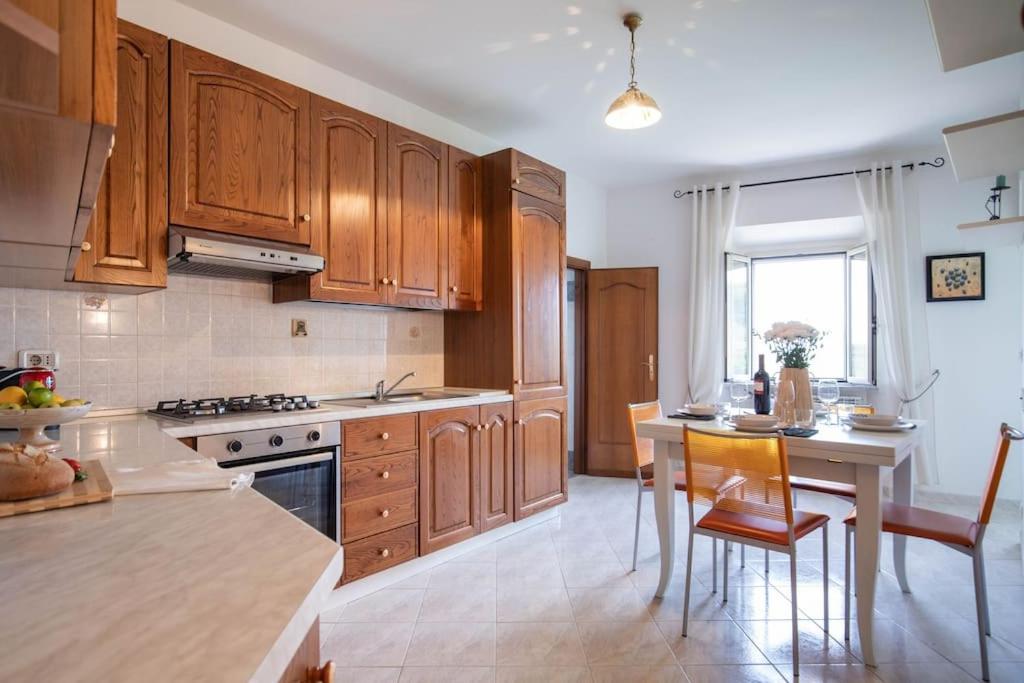 a kitchen with wooden cabinets and a table and chairs at Casa Il Fico in Usigliano