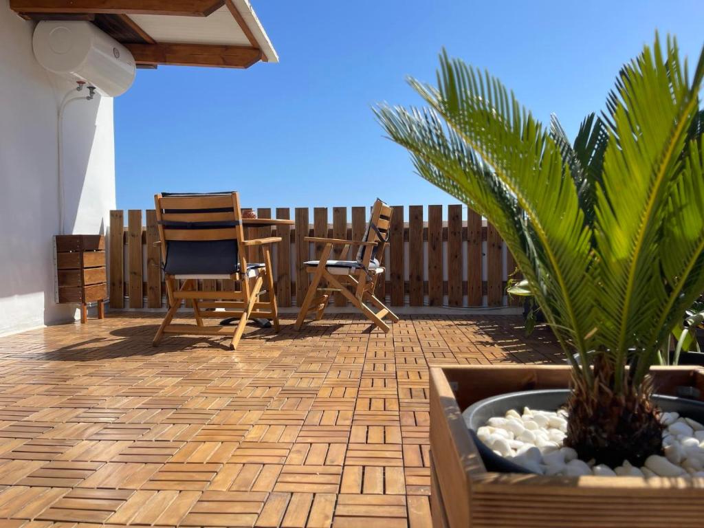 a patio with chairs and a table and a plant at Ρετιρέ με θέα το Ηράκλειο in Heraklio Town