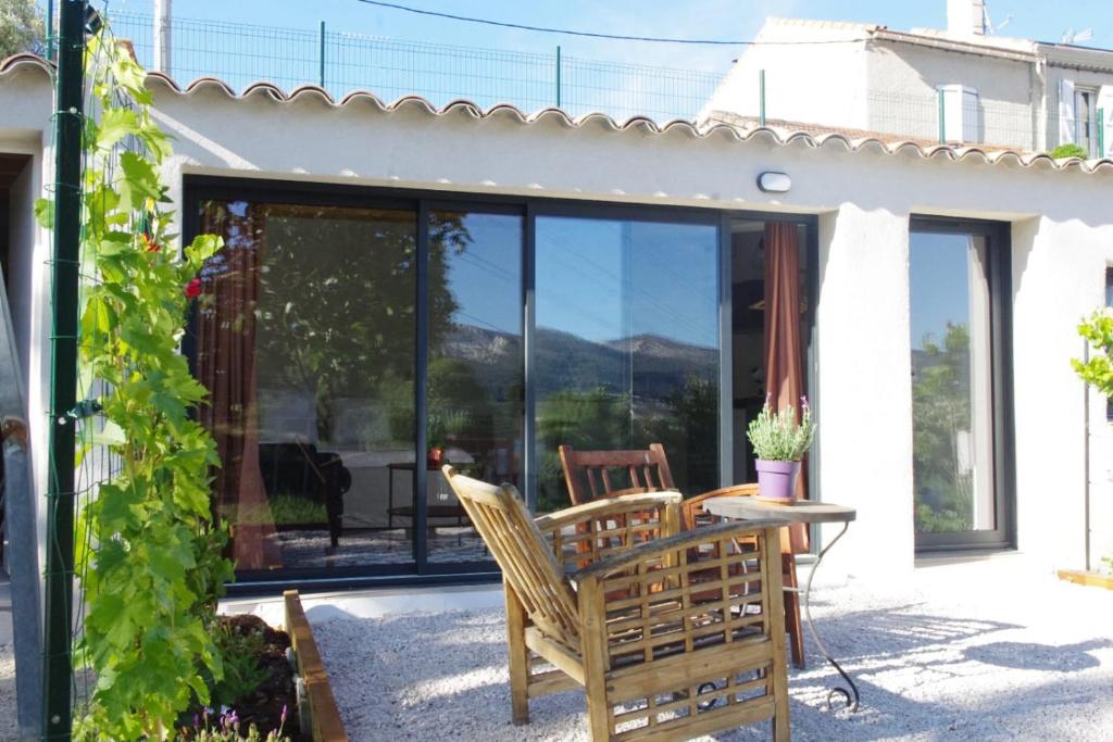 d'une terrasse avec une table, des chaises et des portes en verre. dans l'établissement Les Accatines, à Marseille