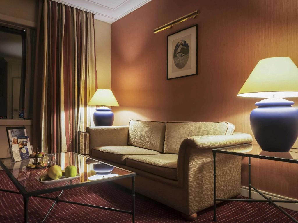 a living room with a couch and a table at Pullman Bucharest World Trade Center in Bucharest