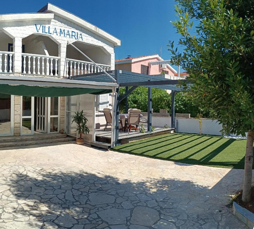 a house with a patio with a lawn at Vila Maria in Vir