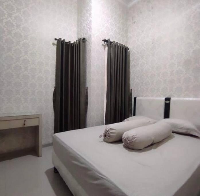 a bedroom with a bed with two pillows on it at Villa Batu Permata Garden in Malang