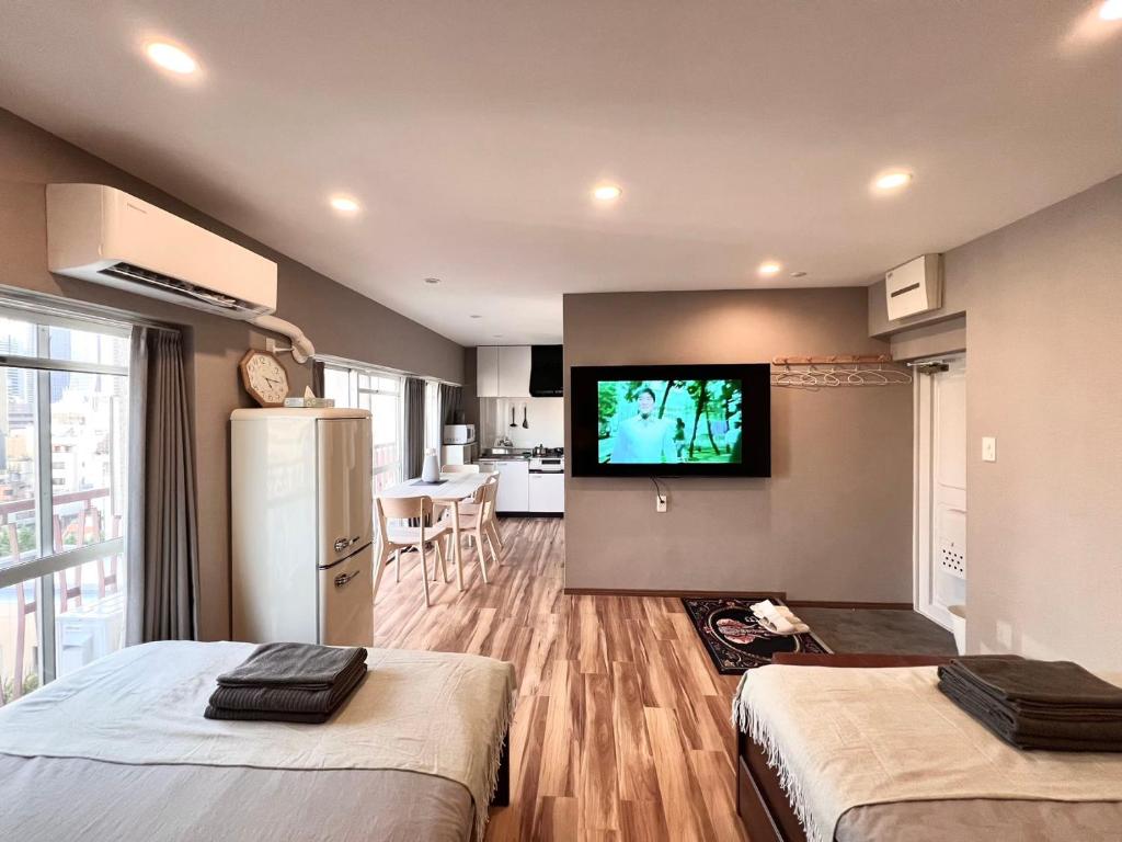 a room with two beds and a television on a wall at JUN 歌舞伎町10Floor-SJ0098 in Tokyo