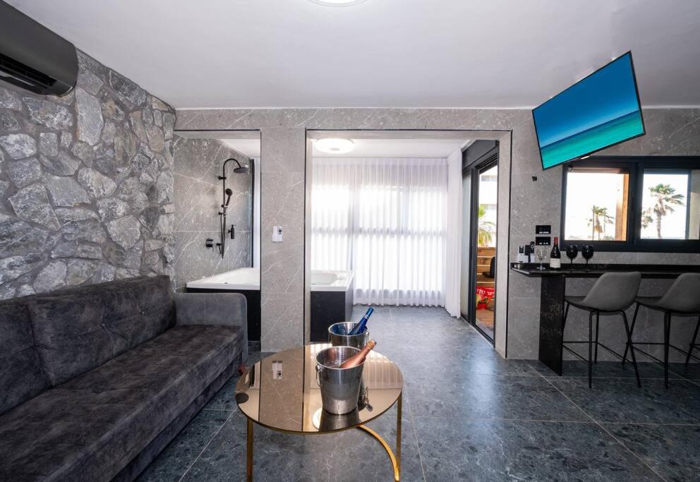a living room with a couch and a table at מבנים בים 75-26 Suites at sea in Haifa
