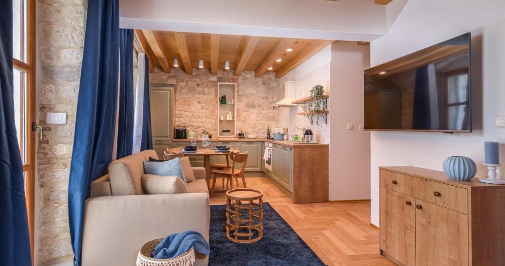 a living room with a couch and a kitchen at Oleander Trogir Suites in Trogir