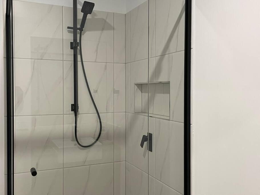 un bagno con doccia con porta in vetro di Peaceful Paradise a Brisbane