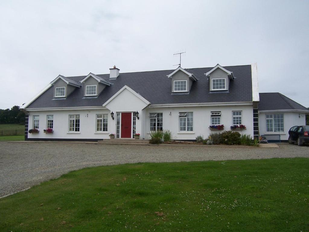 a large white house with a red door at Kilbora B&B in Camolin