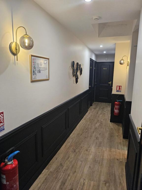 a long hallway with a white wall and a black door at La Caravelle in Aix-en-Provence