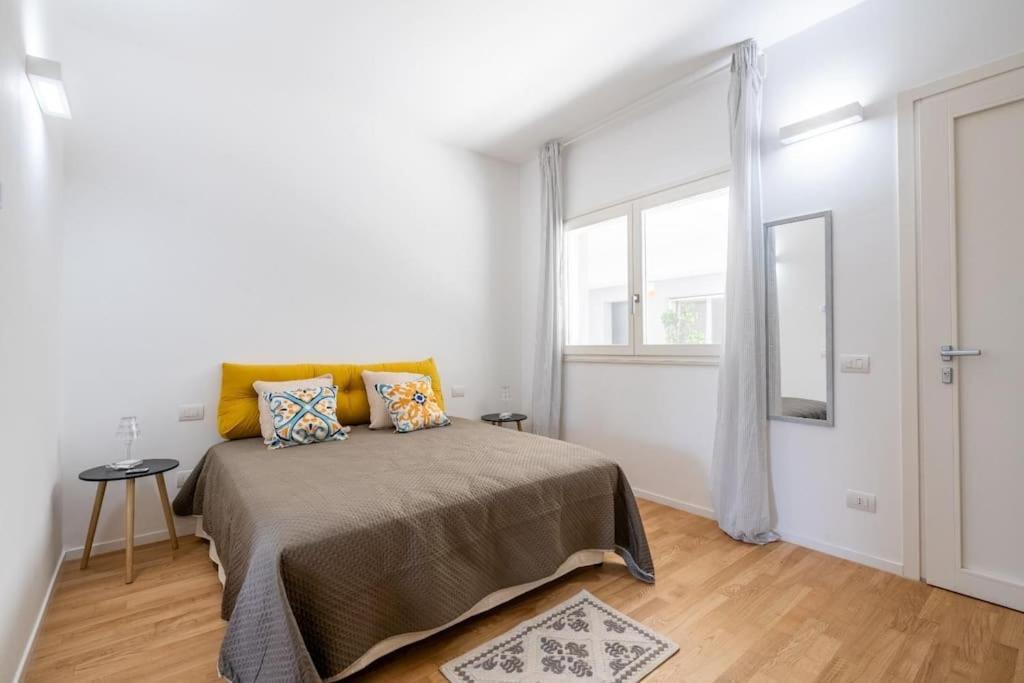 una camera da letto bianca con un letto e una finestra di Benjamin House - Exclusive Modern Loft a Bari