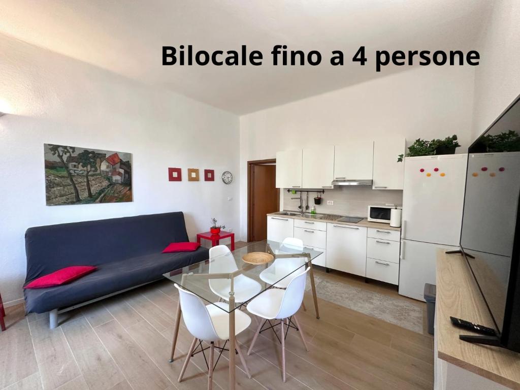 a living room with a blue couch and a glass table at La Casa di Leo Apartments in San Giorgio di Piano