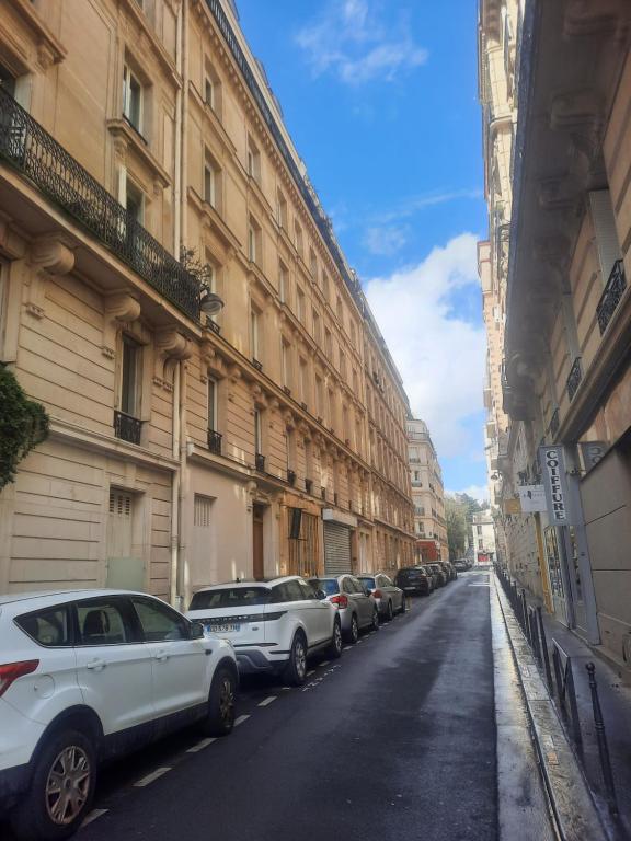 Une rangée de voitures garées dans une rue à côté des bâtiments dans l'établissement Appartement familial dans le 16é, à Paris