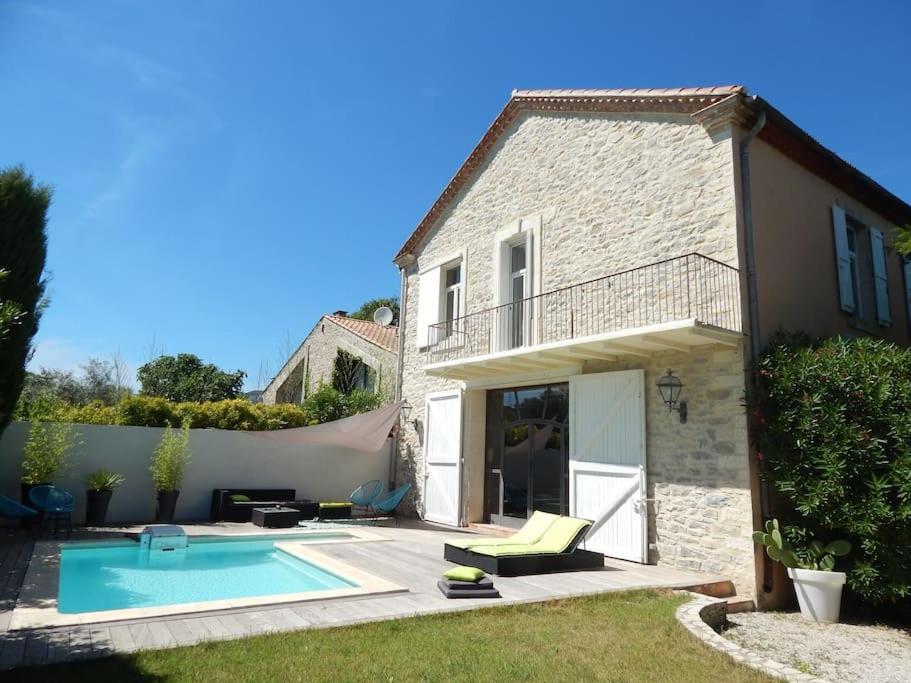 une maison avec une piscine dans la cour dans l'établissement Spacieuse maison de village avec piscine, à Saint-Mathieu-de-Tréviers