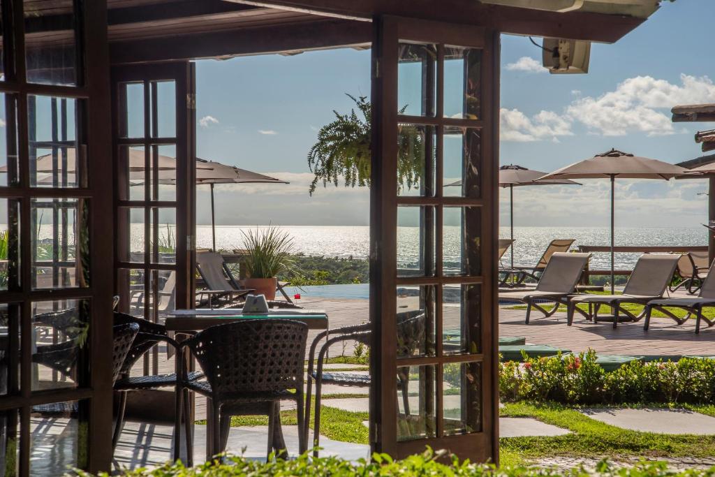 a view of the ocean from the patio of a resort at Manacá Pousada Parque in Arraial d'Ajuda