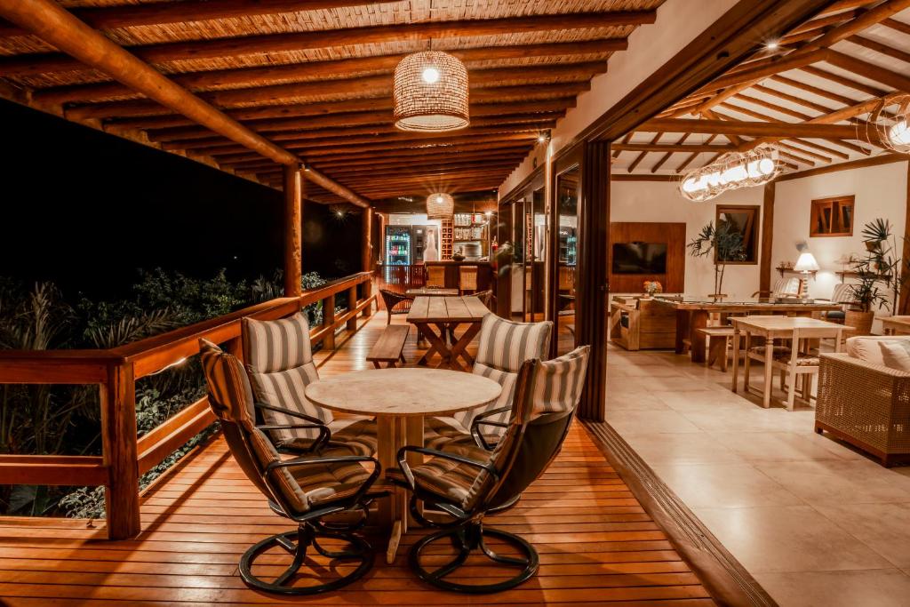 a wooden deck with a table and chairs on it at Manacá Pousada Parque in Arraial d'Ajuda