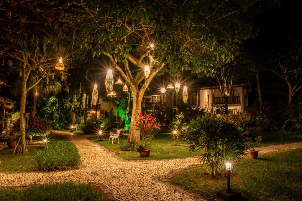 a garden lit up at night with lights at Manacá Pousada Parque in Arraial d'Ajuda