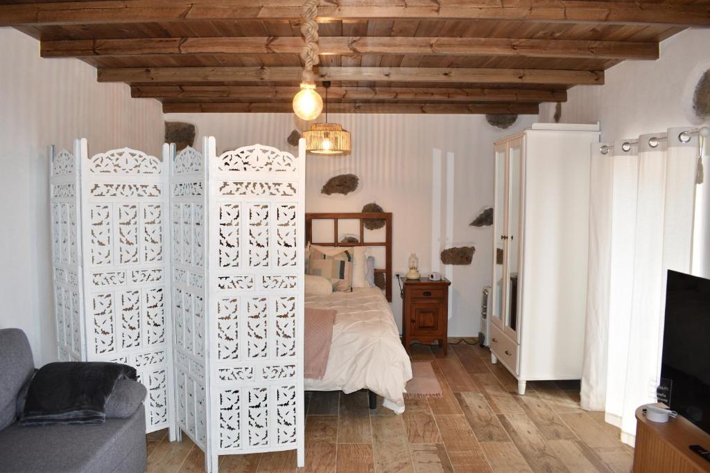 Casas del MonteにあるCasa Rural Delia & Juanの白い仕切りのあるベッドのある寝室