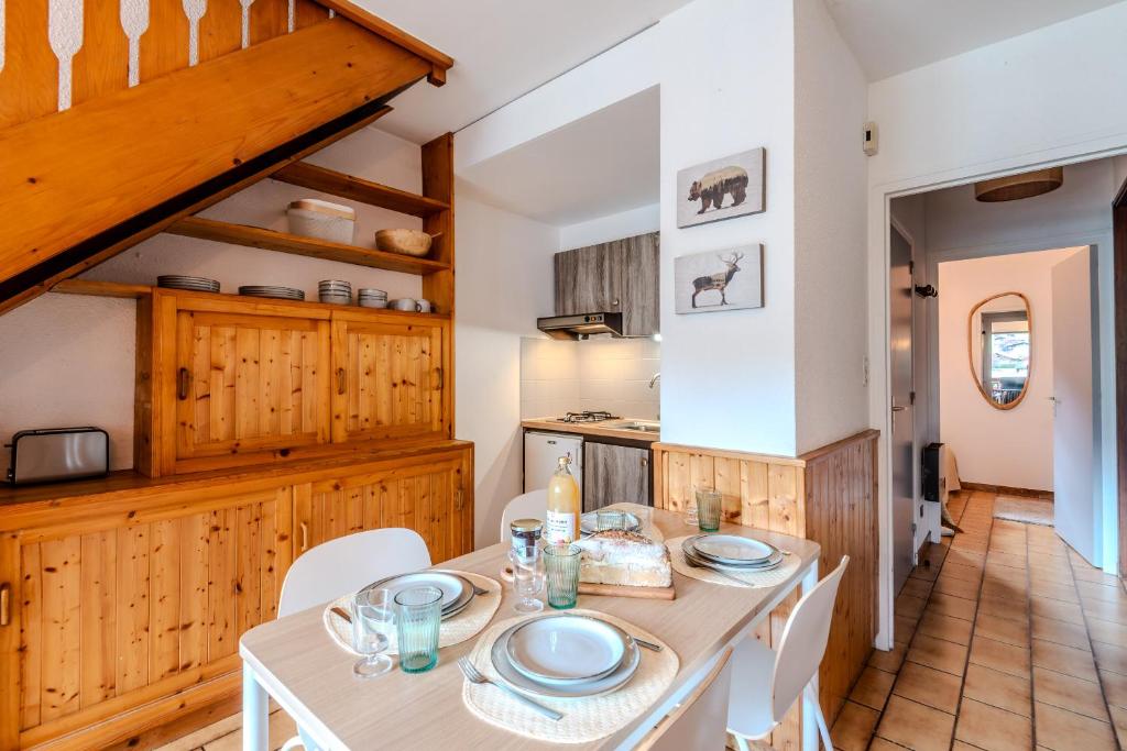 une salle à manger avec une table et des chaises blanches dans l'établissement Ecureuils 1, à Morzine