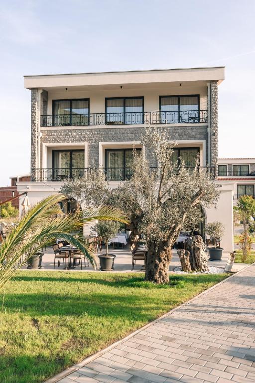 a building with a palm tree in front of it at CAROLEA VILLAS in Ulcinj