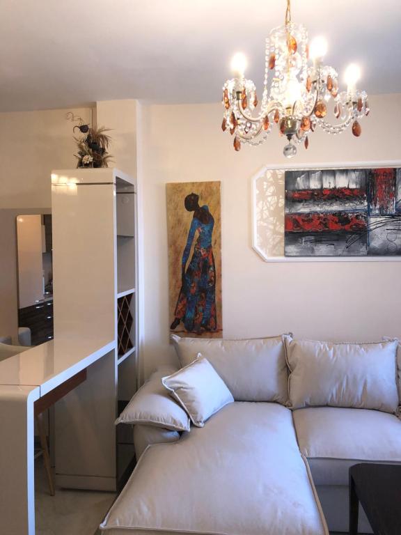 a living room with a couch and a chandelier at Апартамент VESI комплекс ARTUR in Sveti Vlas