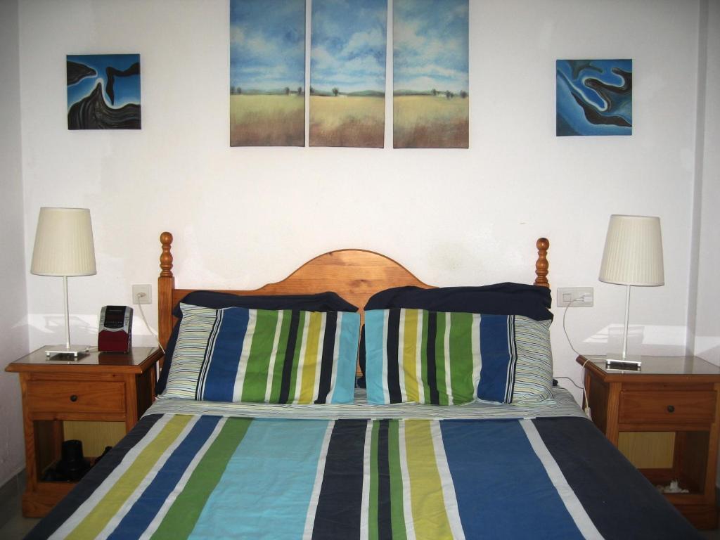 sypialnia z łóżkiem z 2 stolikami nocnymi i 2 lampami w obiekcie Costa del Sol apartment w mieście Benalmádena