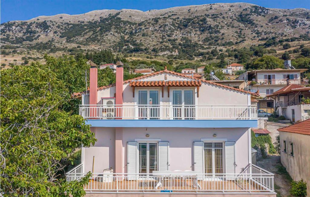 a pink house with a balcony and mountains in the background at Lovely Home In Patra With Kitchen in Patra