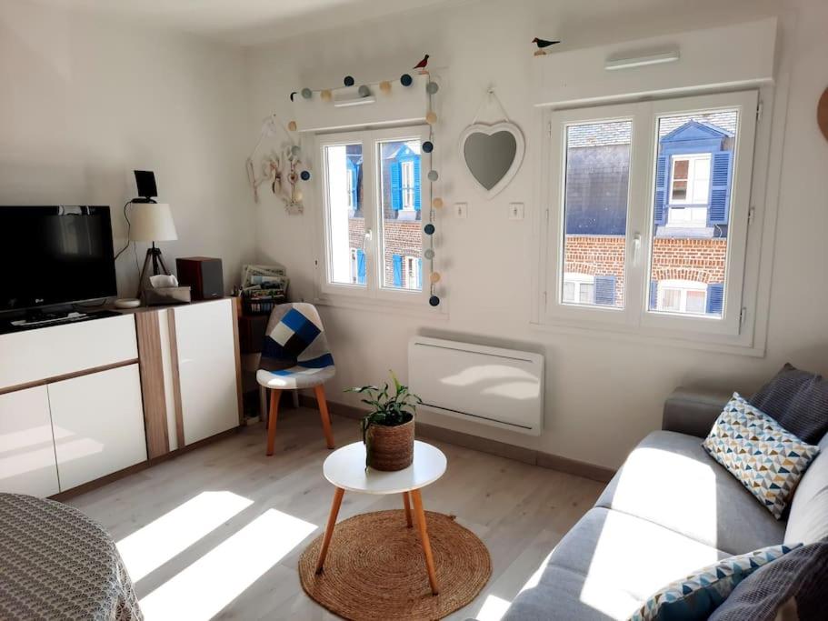 un salon avec un canapé et une table dans l'établissement Studio au cœur du crotoy avec vue sur la baie!, au Crotoy