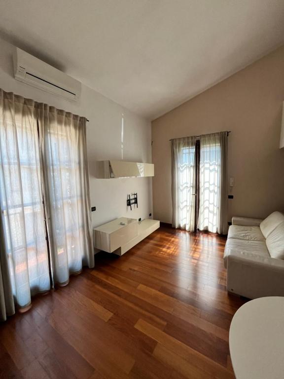 a large living room with wooden floors and windows at Take care of your Holidays in Pisa