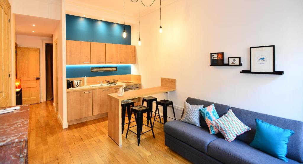 ein Wohnzimmer mit einem Sofa und einer Küche in der Unterkunft Appart' Pasteur in Lyon