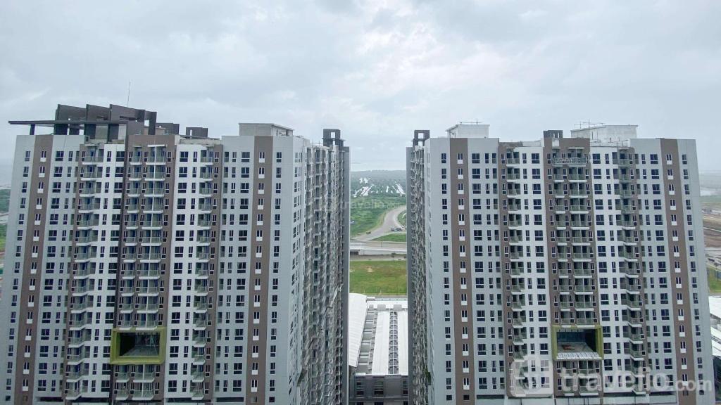 two tall buildings in a city on a cloudy day at Homey and Cozy Designed 2BR at Tokyo Riverside PIK 2 Apartment By Travelio in Rawalembang