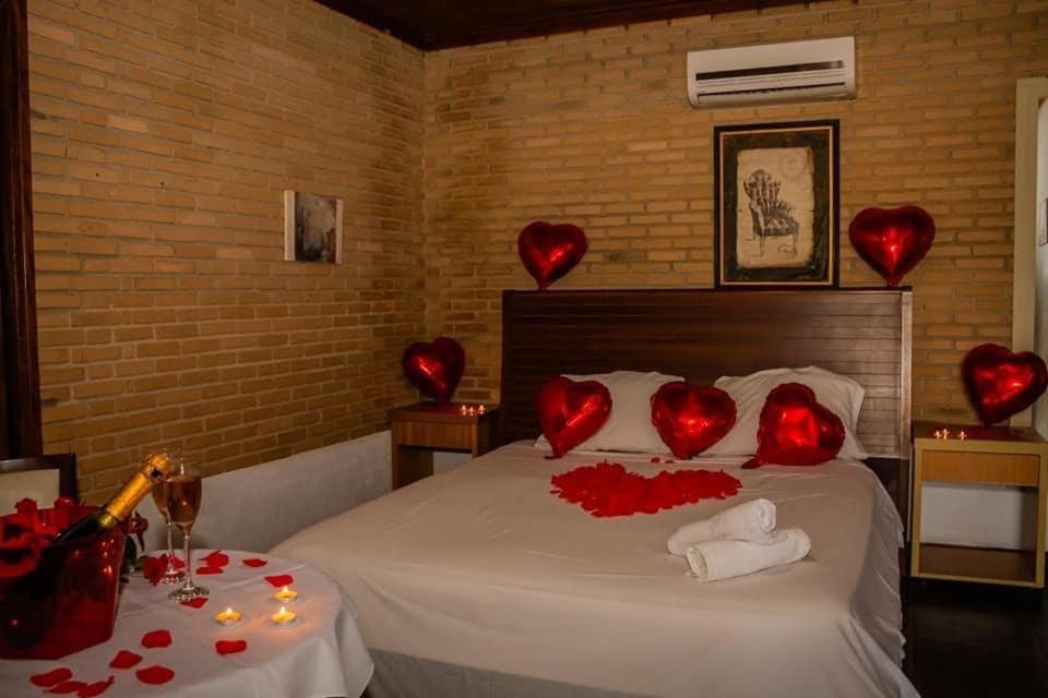 een slaapkamer met een bed met rode harten erop bij Old West Water Park in Santo Antônio do Pinhal
