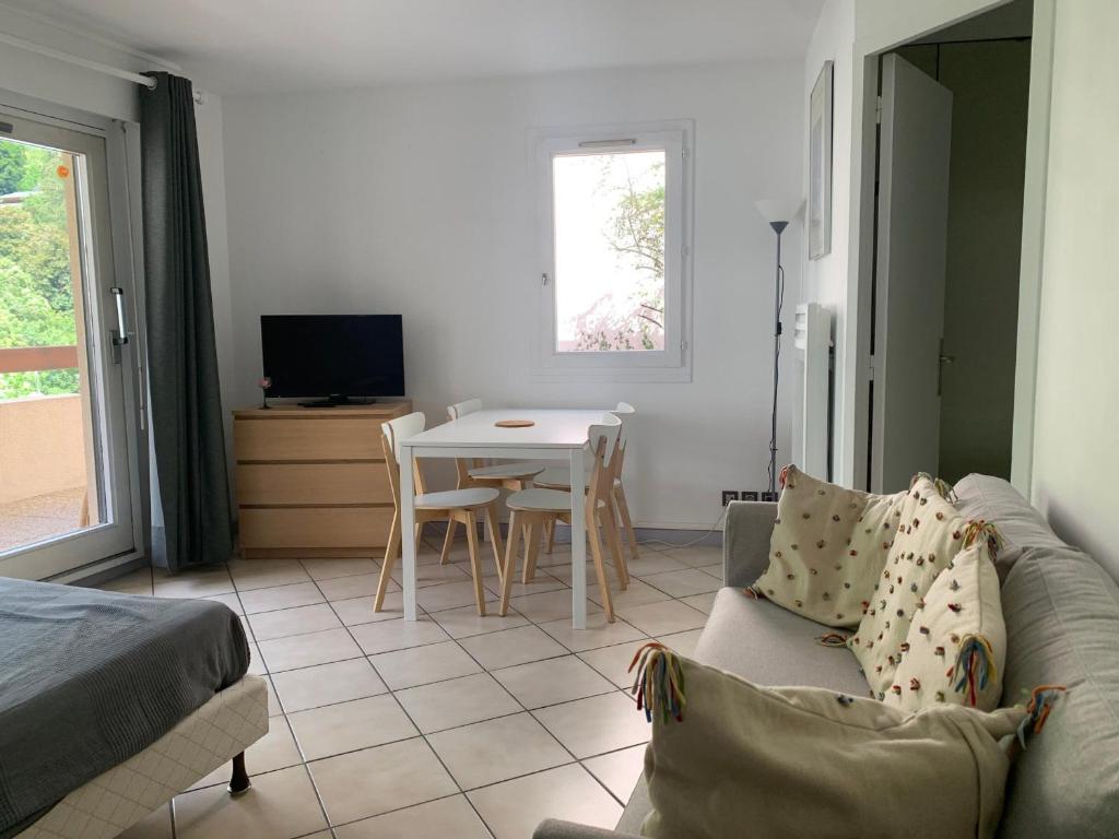 un salon avec un canapé et une table dans l'établissement Studio au cœur de Brides-les-Bains face au parc thermal, balcon, parking, idéal pour curistes et skieurs - FR-1-512-126, à Brides-les-Bains