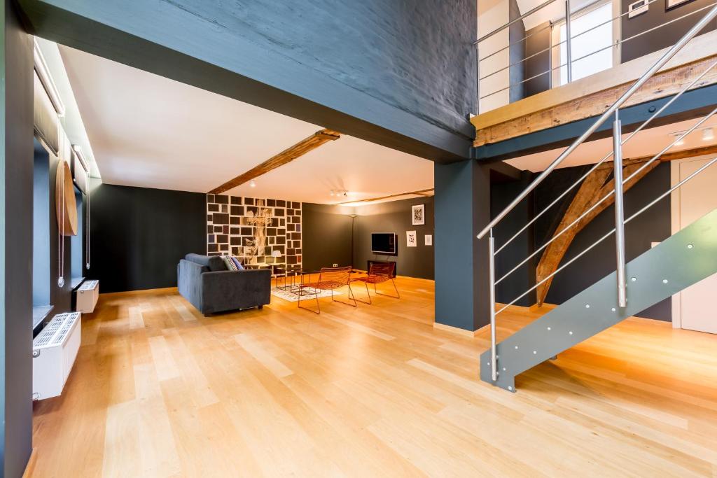 布魯塞爾的住宿－Smartflats - Monnaie，一间带楼梯和沙发的客厅