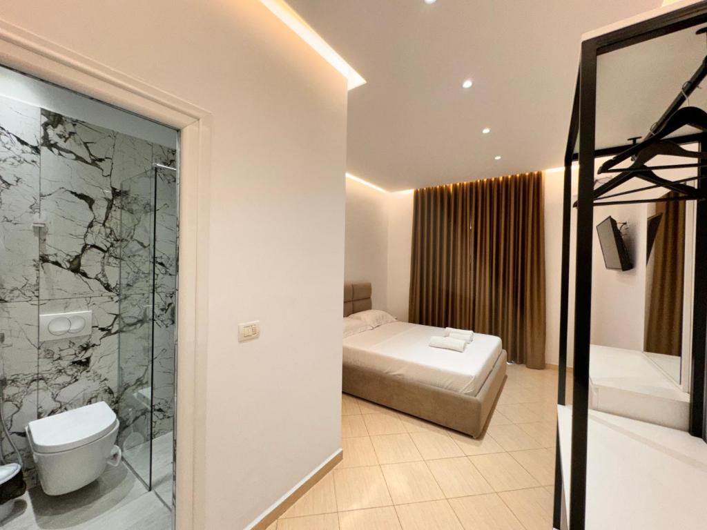 a bathroom with a bed and a shower and a toilet at Dine Hotel in Ksamil