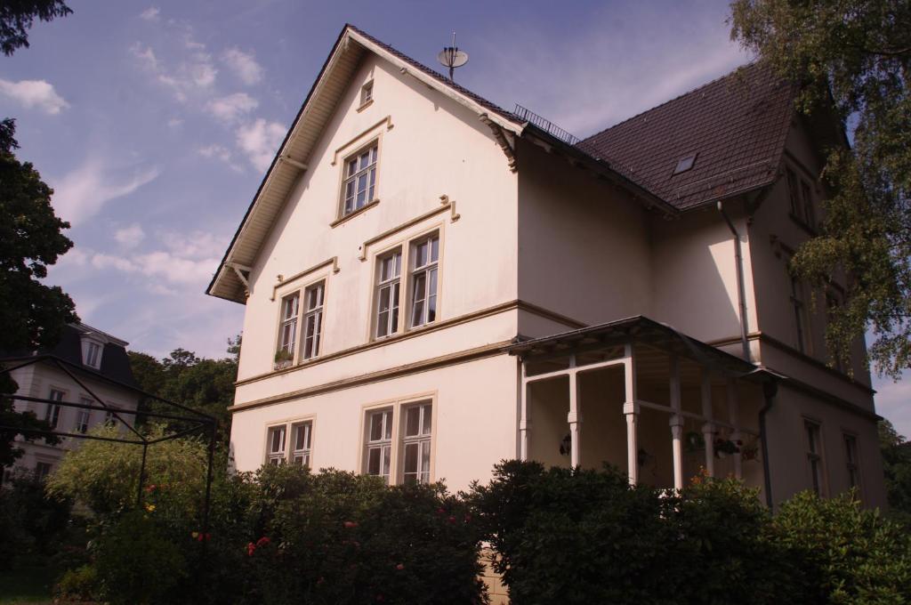 a white house with a black roof at Ferienwohnung Villa Weyermann in Leichlingen