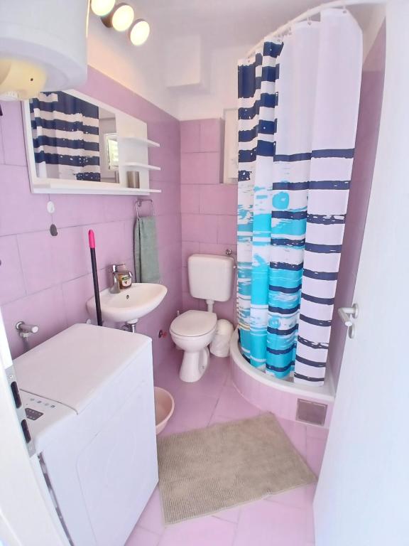 różowa łazienka z toaletą i umywalką w obiekcie Apartments Neo w mieście Rukavac