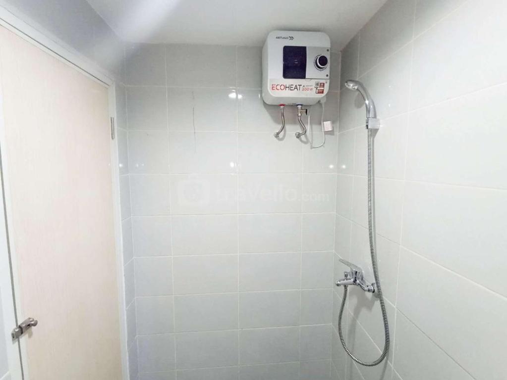 baño con ducha con una cámara en la pared en Modern Look and Homey Studio Amartha View Apartment By Travelio, en Semarang